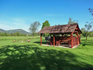 pergola za chalupou a vedle ní ohniště