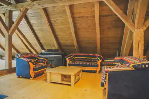 krbová kamna, sedací souprava, piano a kytara - společenská místnost v prvním patře