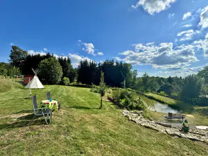 travnatá plocha s teepee a badmintonovou sítí