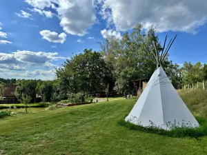 travnatá plocha s teepee a badmintonovou sítí