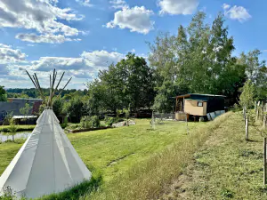 travnatá plocha s teepee a badmintonovou sítí